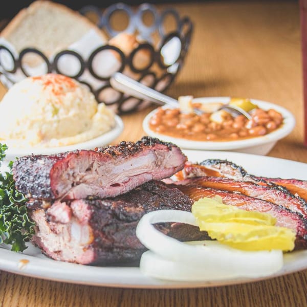 Barbecue Inn's BBQ ribs and brisket with potato salad, baked beans, onions, and pickles.